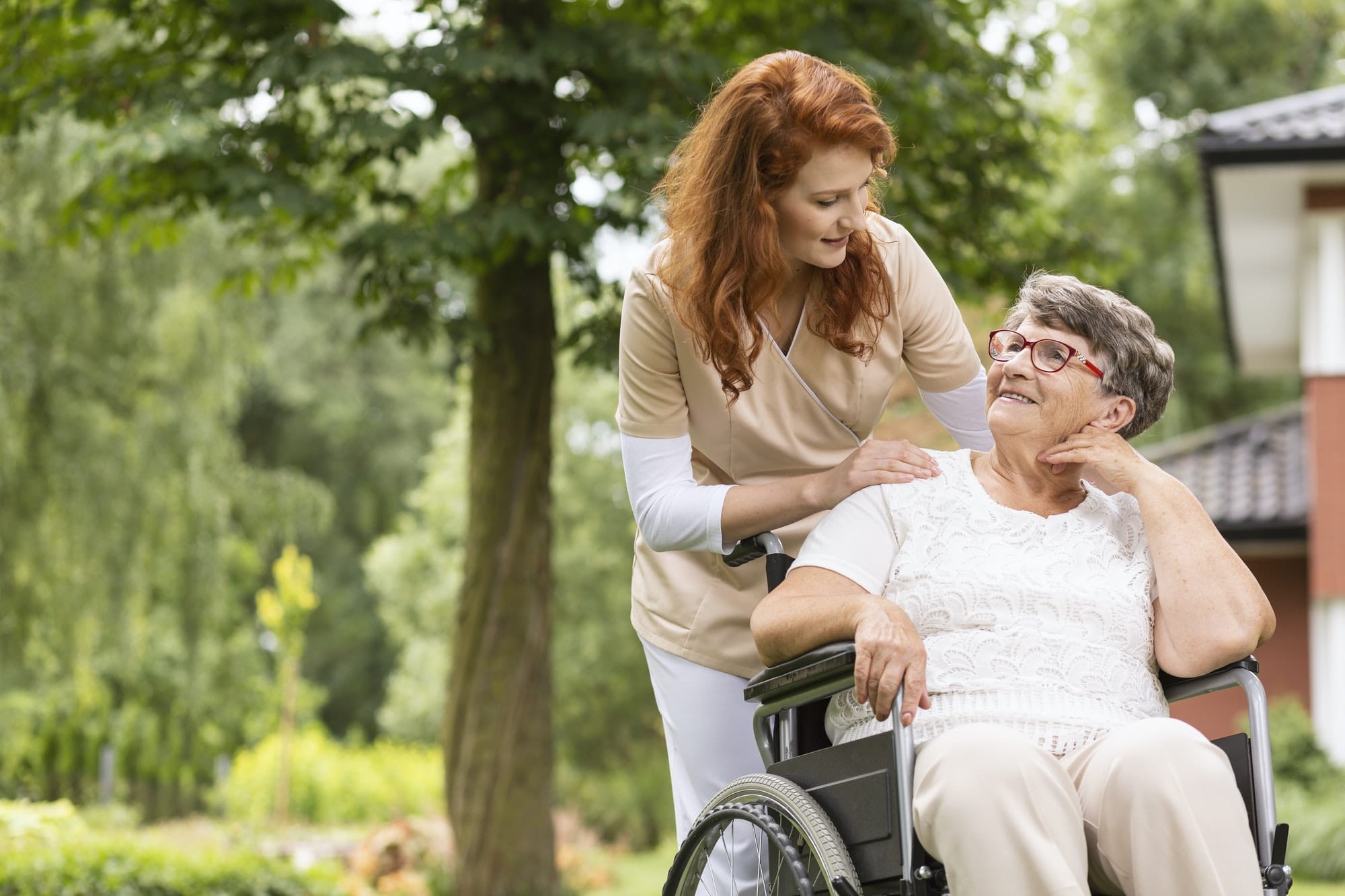 A female volunteer helping an elderly woman in a wheelchair in t